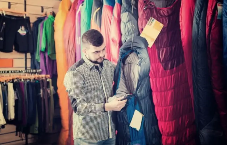 A man inspects a sleeping bag before purchasing it.