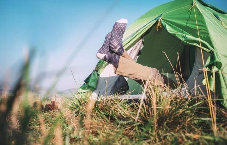 Camper legs in socks stick out from tent
