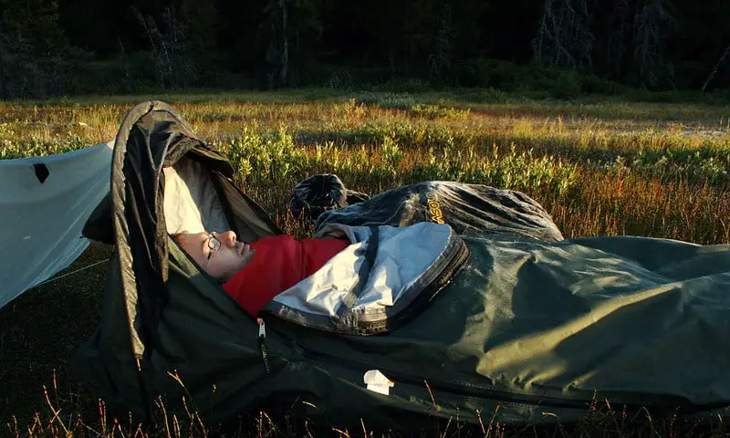 A man sleeping inside a bivvy bag